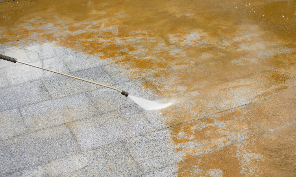 Surface being cleaned with a pressure washer, showing a striking contrast between the cleaned and uncleaned areas